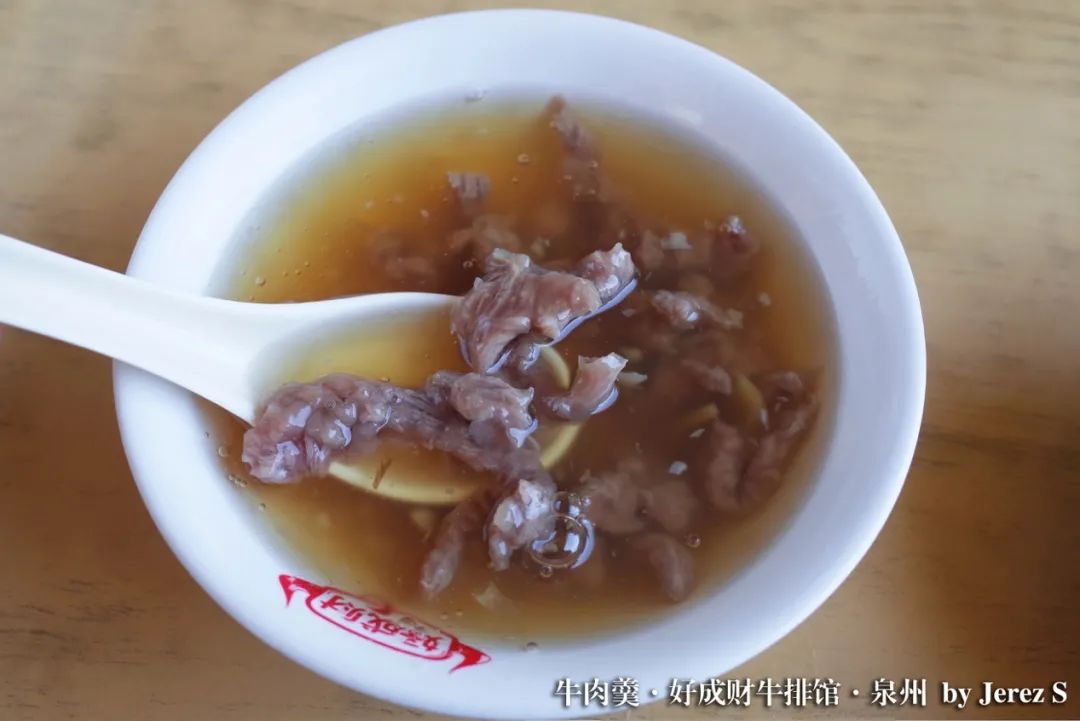 A bowl of clear Quanzhou beef soup with tender beef strips and ginger